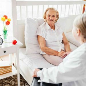 Providing care for elderly. Doctor visiting elderly patient at home.